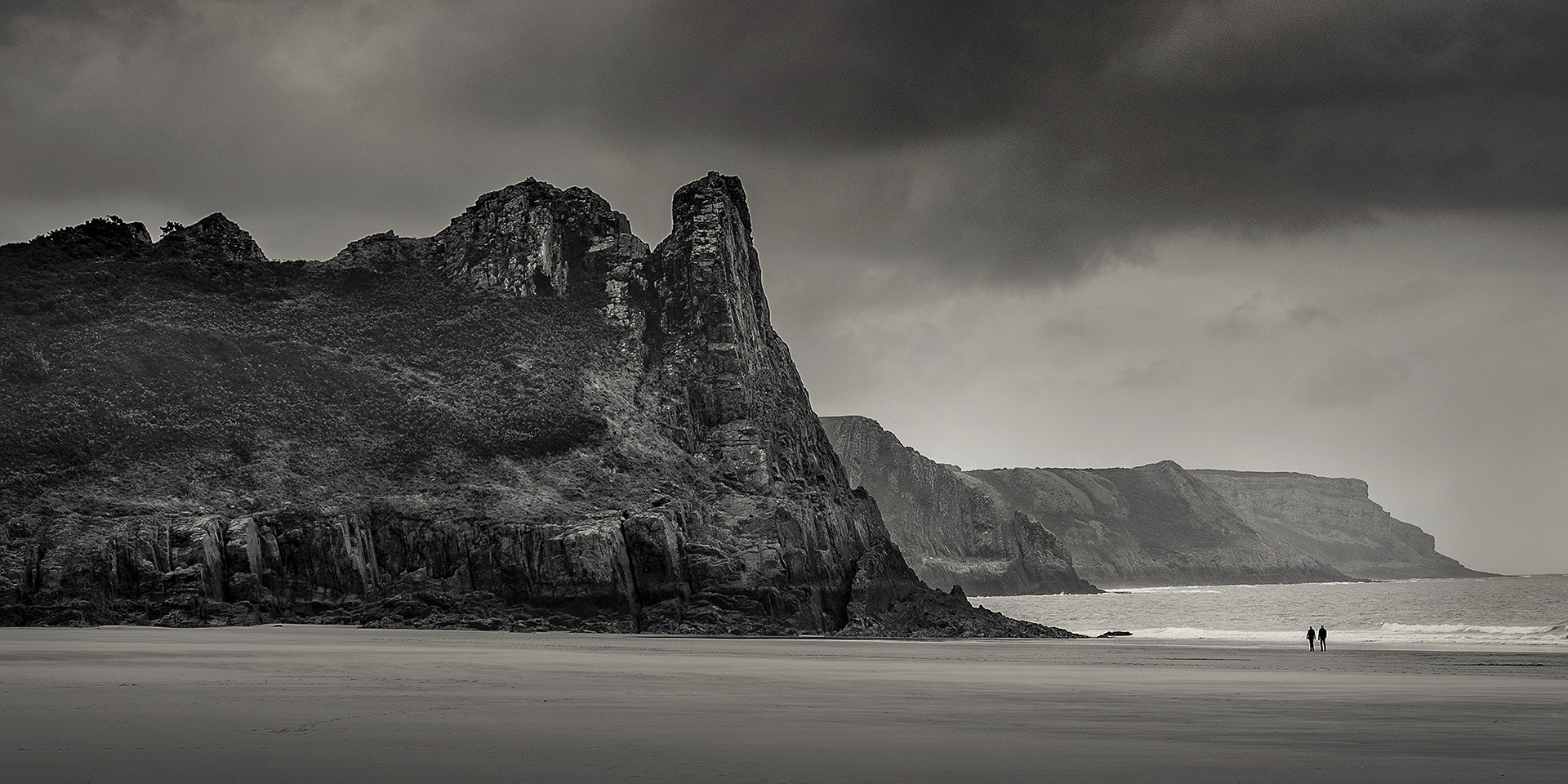 couple walking near three cliffs bay, gower, west wales