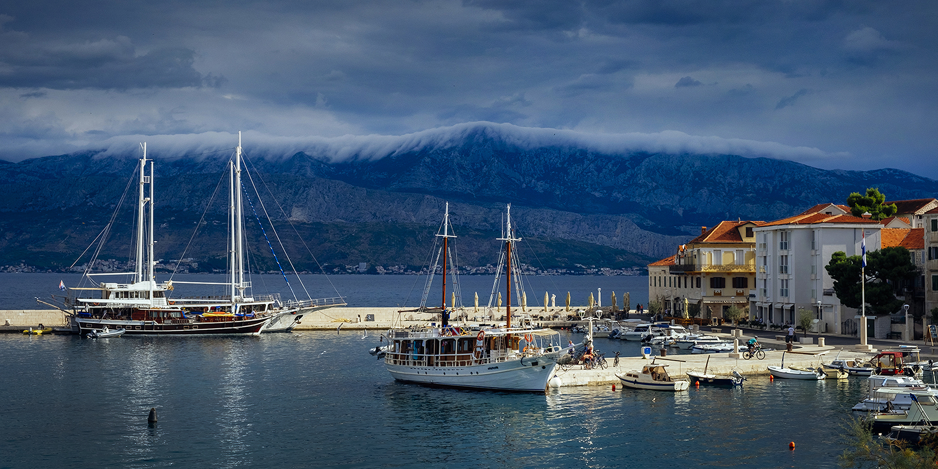 Postira harbour with cloud inversion on Croatian mountains, Brac, croatia